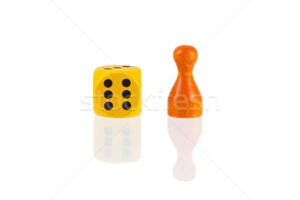 Stock photo: One orange pawn and a yellow dice 