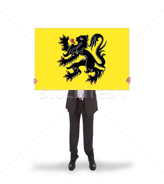 Smiling businessman holding a big card, flag of Flanders Stock photo © michaklootwijk