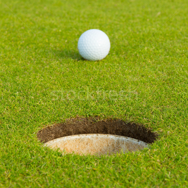 Golf ball in front of the hole, focus on the hole Stock photo © michaklootwijk