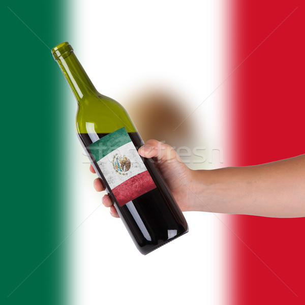 Kéz tart üveg vörösbor címke Mexikó Stock fotó © michaklootwijk