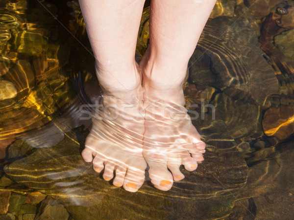 Dipping feet in water off a stone beach Stock photo © michaklootwijk