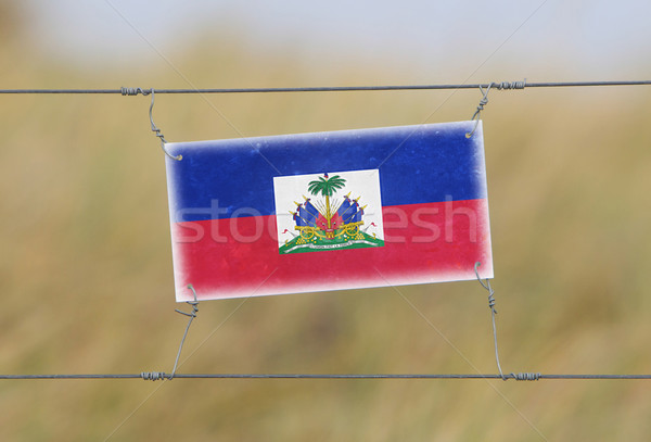 Border fence - Old plastic sign with a flag Stock photo © michaklootwijk