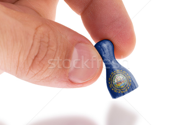 Hand holding wooden pawn, flag painting, selective focus Stock photo © michaklootwijk