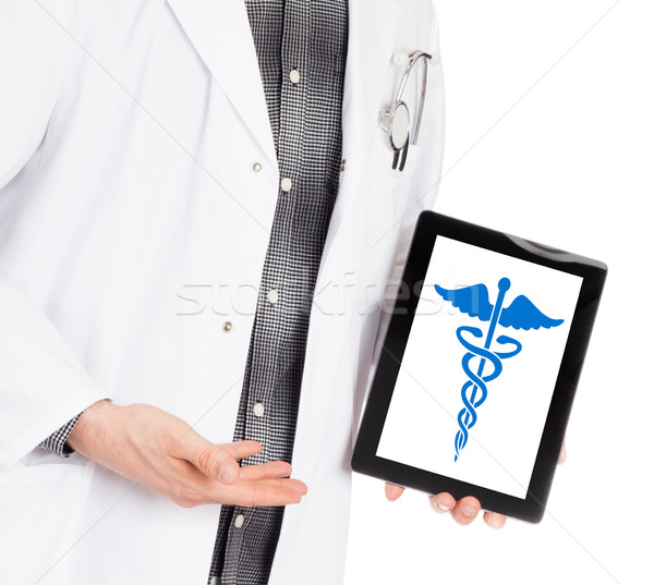 Doctor holding tablet - Caduceus symbol Stock photo © michaklootwijk