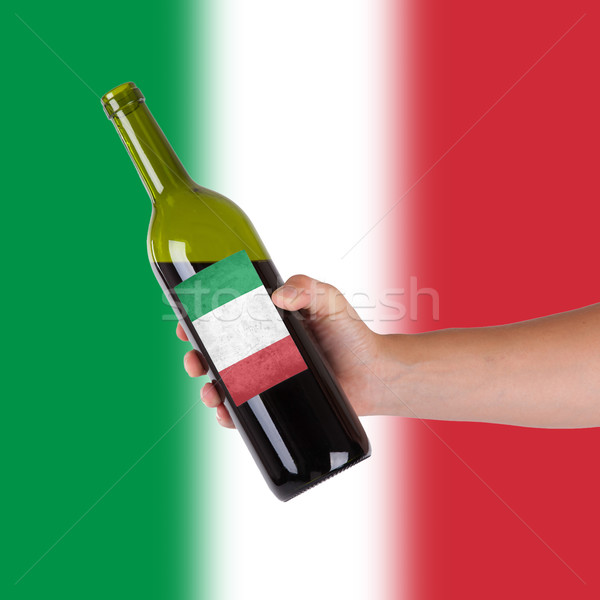 Kéz tart üveg vörösbor címke Olaszország Stock fotó © michaklootwijk