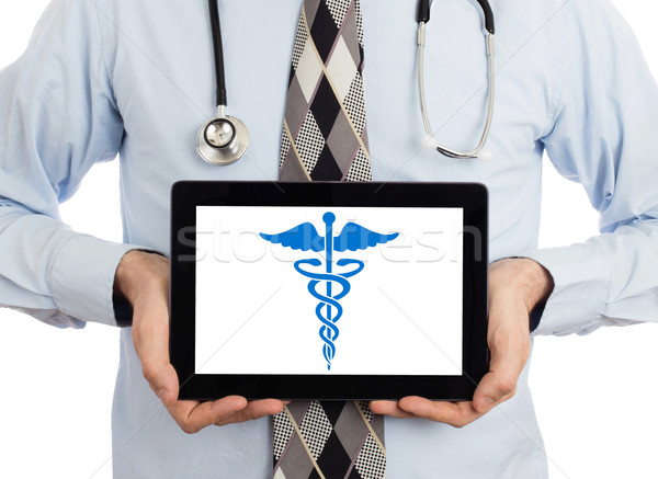 Doctor holding tablet - Caduceus symbol Stock photo © michaklootwijk