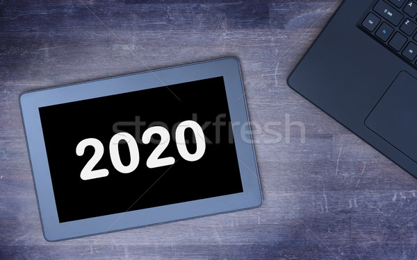 Tablet touch computer gadget on wooden table - 2020 Stock photo © michaklootwijk