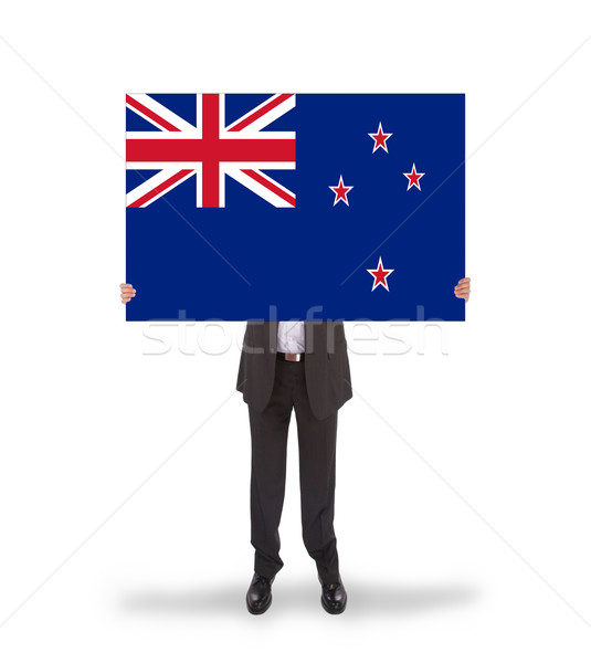 Smiling businessman holding a big card, flag of New Zealand Stock photo © michaklootwijk