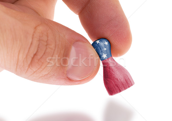 Hand holding wooden pawn, flag painting, selective focus Stock photo © michaklootwijk