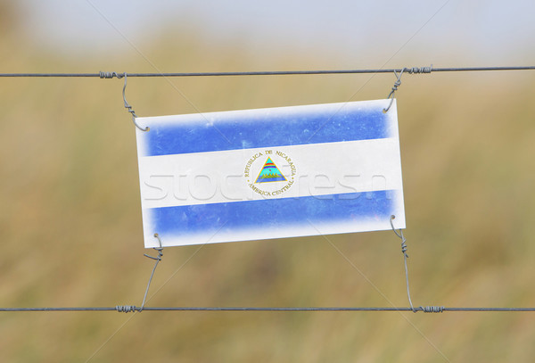 Border fence - Old plastic sign with a flag Stock photo © michaklootwijk