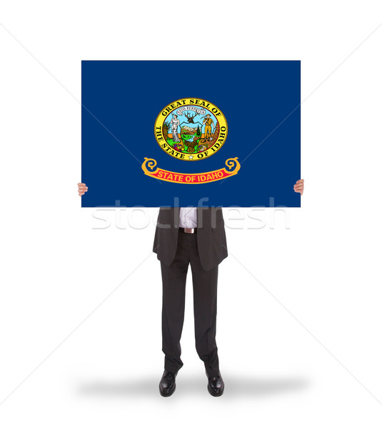 Smiling businessman holding a big card, flag of Idaho Stock photo © michaklootwijk