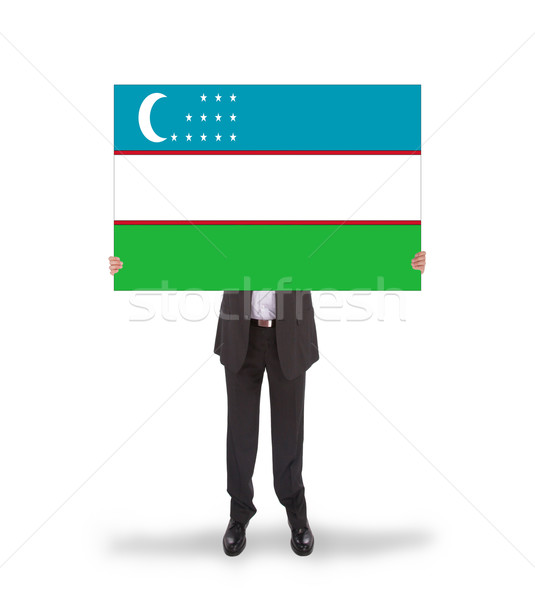 Businessman holding a big card, flag of Uzbekistan Stock photo © michaklootwijk