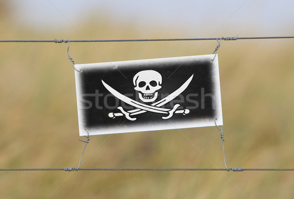 Border fence - Old plastic sign with a flag Stock photo © michaklootwijk