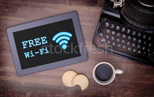 Tablet with Wi-Fi connection on a wooden desk Stock photo © michaklootwijk