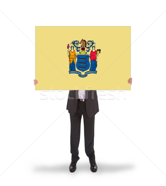 Smiling businessman holding a big card, flag of New Jersey Stock photo © michaklootwijk