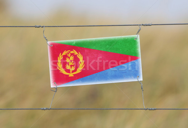 Border fence - Old plastic sign with a flag Stock photo © michaklootwijk