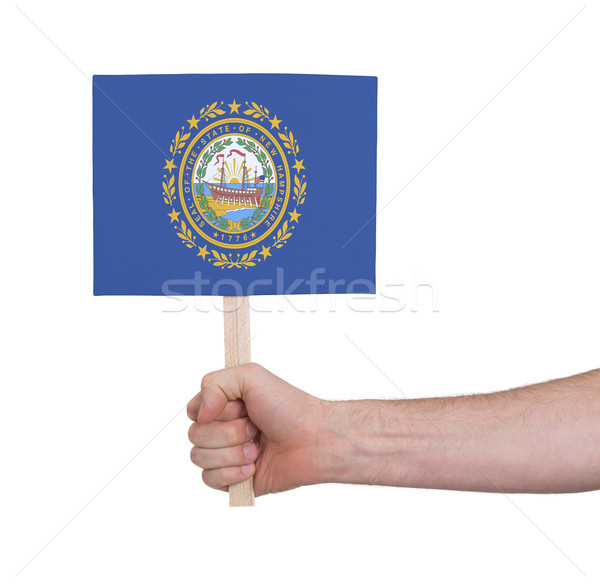 Stock photo: Hand holding small card - Flag of New Hampshire