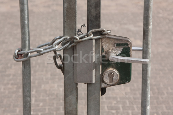 A chain hanging on a abandoned gate Stock photo © michaklootwijk