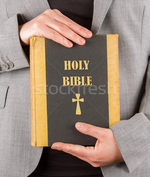 Stock photo: Woman in business suit is holding a holy bible