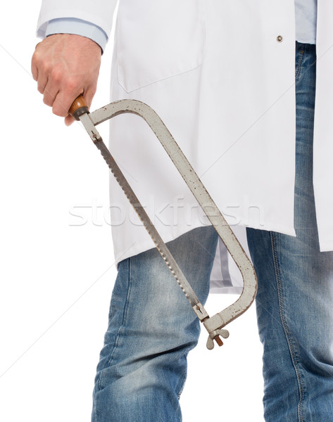 Stock photo: Crazy doctor is holding a big saw in his hands