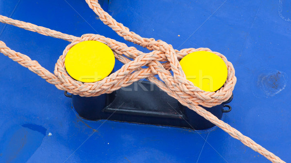 Twisted orange rope round a yellow bollard Stock photo © michaklootwijk