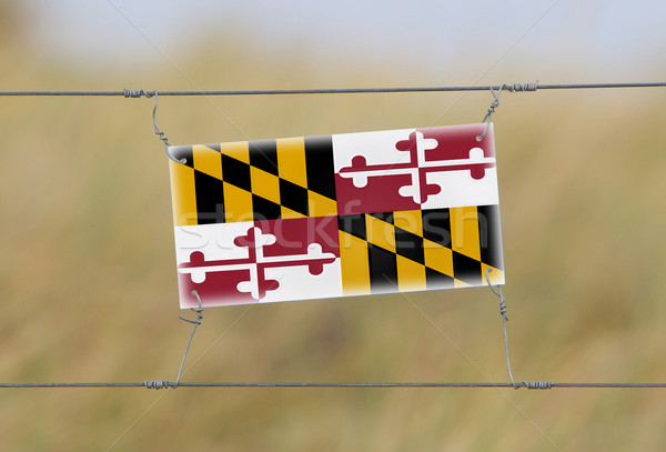 Border fence - Old plastic sign with a flag Stock photo © michaklootwijk