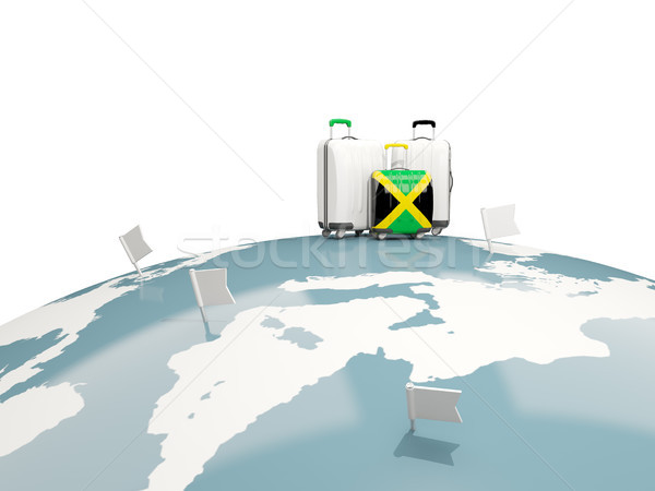 Luggage with flag of jamaica. Three bags on top of globe Stock photo © MikhailMishchenko