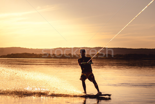 Wakeboarding. Athlete silhouette with splash of water Stock photo © MikhailMishchenko