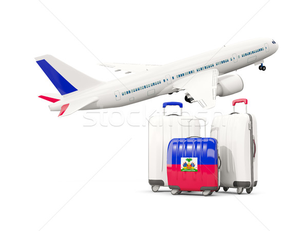 Luggage with flag of haiti. Three bags with airplane Stock photo © MikhailMishchenko