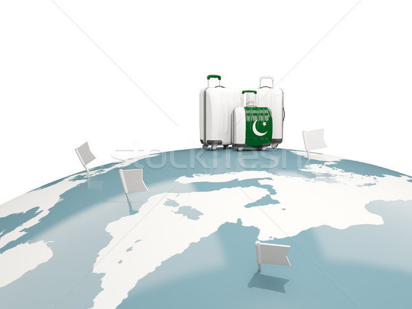 Luggage with flag of pakistan. Three bags on top of globe Stock photo © MikhailMishchenko