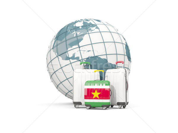 Luggage with flag of suriname. Three bags in front of globe Stock photo © MikhailMishchenko