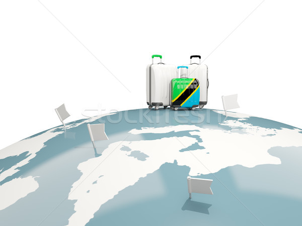 Luggage with flag of tanzania. Three bags on top of globe Stock photo © MikhailMishchenko