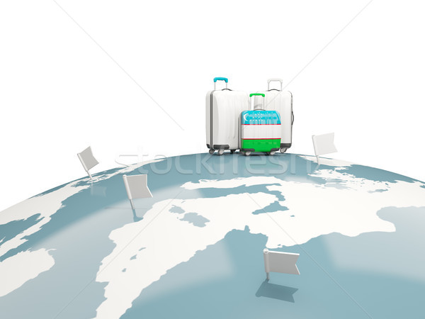 Luggage with flag of uzbekistan. Three bags on top of globe Stock photo © MikhailMishchenko