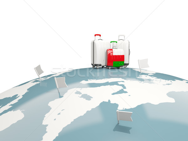 Luggage with flag of oman. Three bags on top of globe Stock photo © MikhailMishchenko