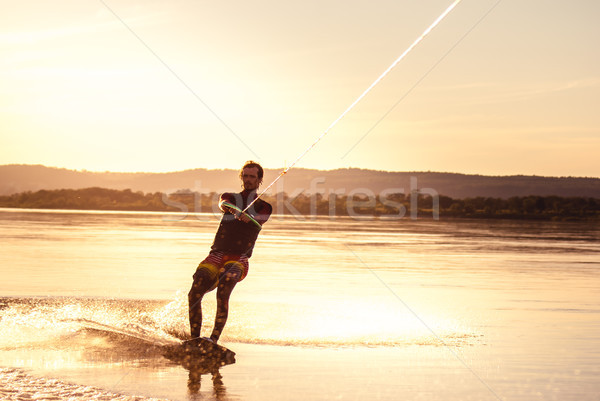 Stock photo: Wakeboarding. Athlete silhouette with splash of water