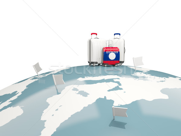 Luggage with flag of laos. Three bags on top of globe Stock photo © MikhailMishchenko