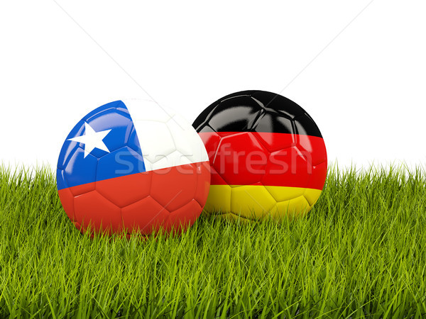 Two footballs with flags of Chile and Germany on green grass Stock photo © MikhailMishchenko
