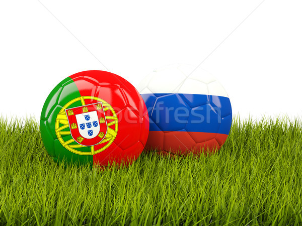 Two footballs with flags of Portugal and Russia on green grass Stock photo © MikhailMishchenko