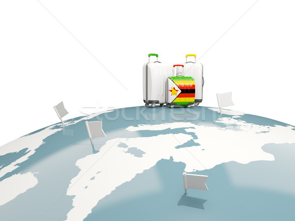 Luggage with flag of zimbabwe. Three bags on top of globe Stock photo © MikhailMishchenko