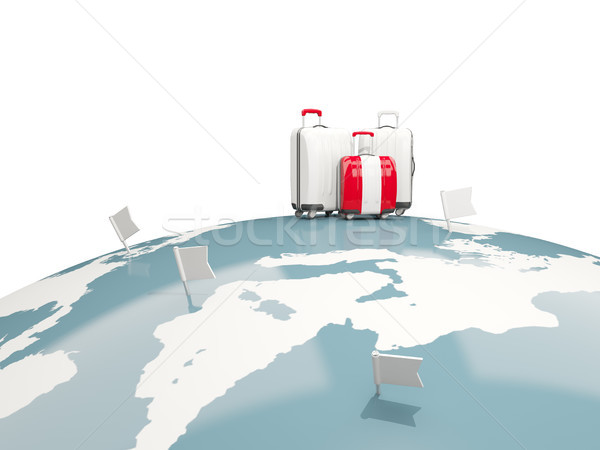 Luggage with flag of peru. Three bags on top of globe Stock photo © MikhailMishchenko
