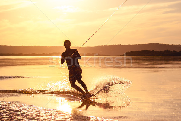 Stock photo: Wakeboarding. Athlete silhouette with splash of water