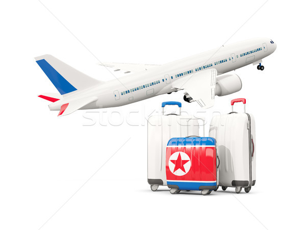 Luggage with flag of korea north. Three bags with airplane Stock photo © MikhailMishchenko