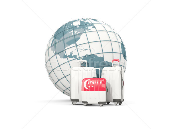 Luggage with flag of singapore. Three bags in front of globe Stock photo © MikhailMishchenko