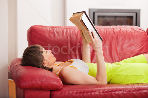 женщину чтение книга диване книга в твердой обложке домой Сток-фото © MikLav