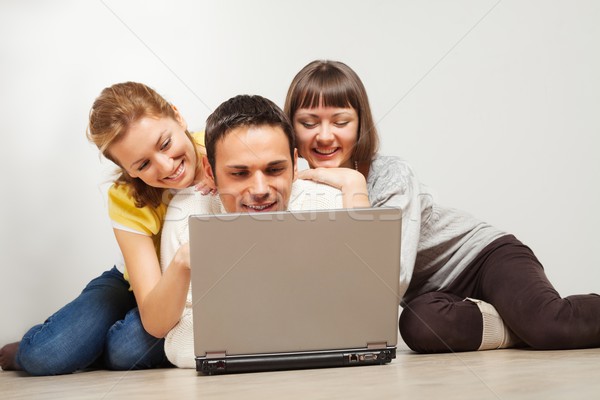 Happy friends with laptop computer Stock photo © MikLav