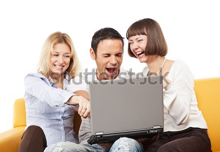 Stock photo: Amused young people with laptop computer