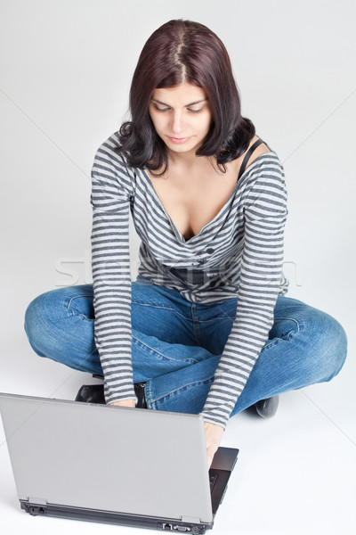 漂亮 年輕女子 筆記本電腦 地板 筆記本電腦 牛仔褲 商業照片 © MikLav