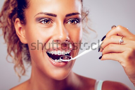 Nina tirantes primer plano sonriendo limpieza dientes Foto stock © MilanMarkovic78