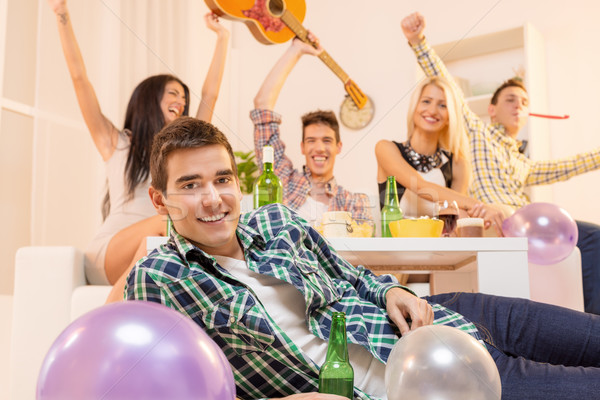 Młodych facet house party piętrze uśmiechnięty patrząc Zdjęcia stock © MilanMarkovic78