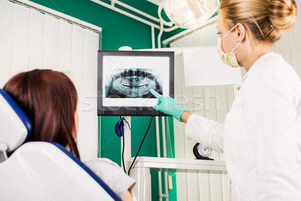 Dentist showing to the patient X-ray picture Stock photo © MilanMarkovic78